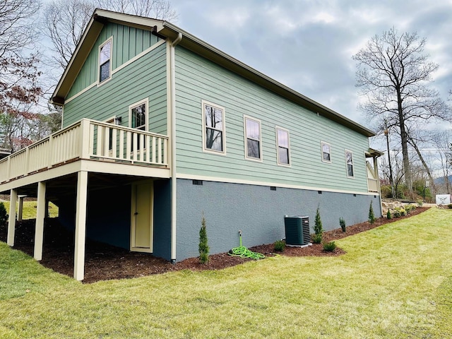 view of side of home with central AC, a yard, and a deck