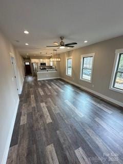 unfurnished living room with ceiling fan and dark hardwood / wood-style flooring