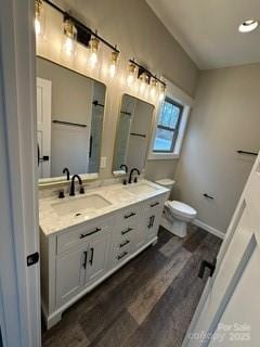 bathroom featuring wood-type flooring, vanity, and toilet