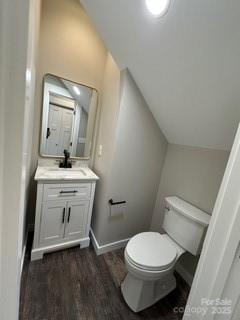 bathroom featuring hardwood / wood-style flooring, vanity, lofted ceiling, and toilet