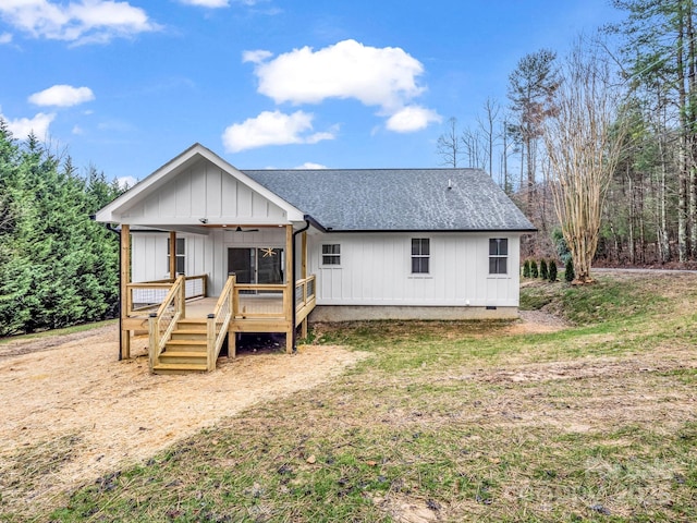 rear view of property featuring a porch and a yard