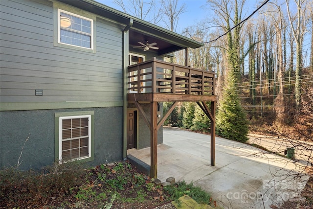 view of side of home featuring a deck, ceiling fan, and a patio area