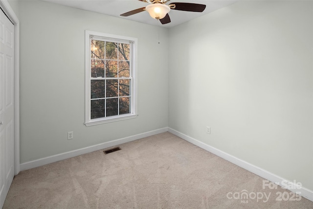 carpeted empty room featuring ceiling fan