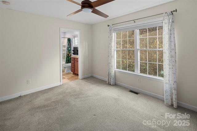 carpeted empty room with plenty of natural light and ceiling fan