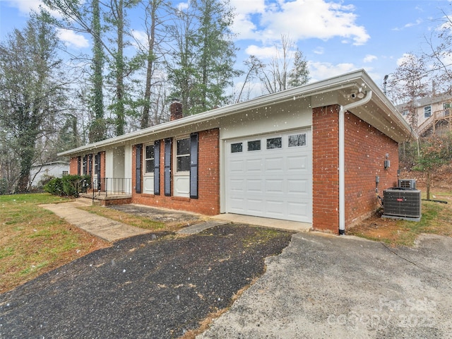 single story home with a garage and central air condition unit