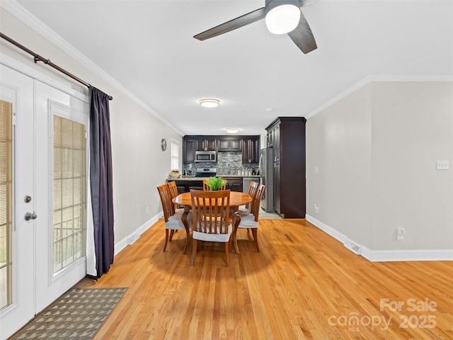 dining space with ceiling fan, ornamental molding, and light hardwood / wood-style flooring