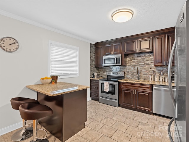 kitchen featuring a kitchen bar, appliances with stainless steel finishes, dark brown cabinetry, and sink