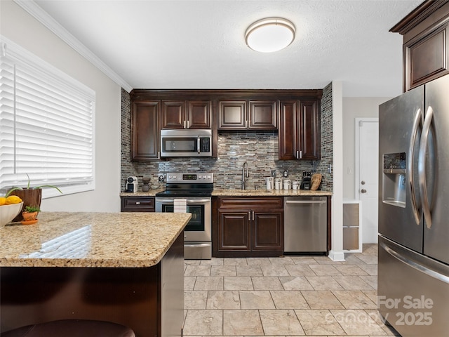 kitchen with light stone countertops, decorative backsplash, dark brown cabinets, and stainless steel appliances