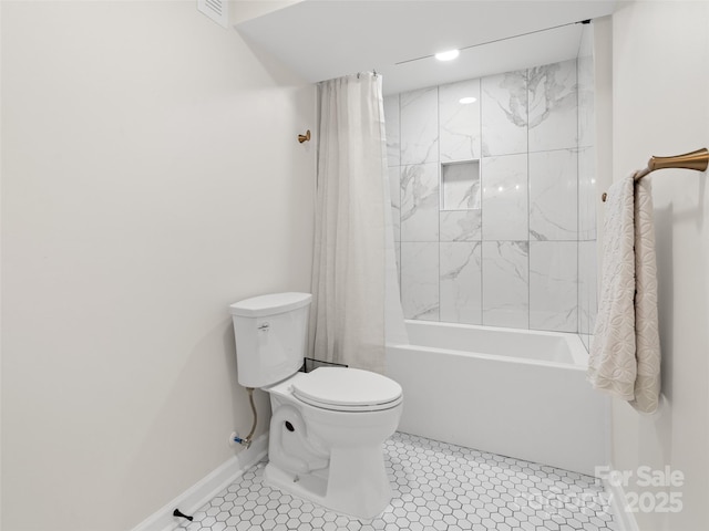 bathroom with tile patterned floors, shower / bath combination with curtain, and toilet