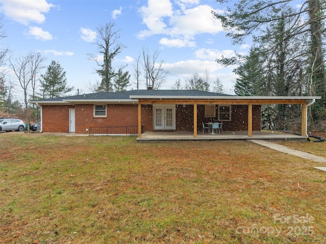 rear view of property with french doors, a yard, and a patio area