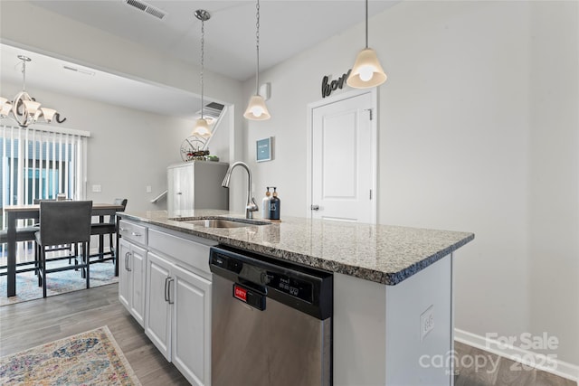 kitchen with sink, pendant lighting, dishwasher, white cabinetry, and an island with sink