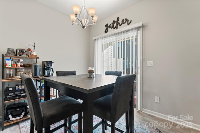 dining space with wood-type flooring and a chandelier