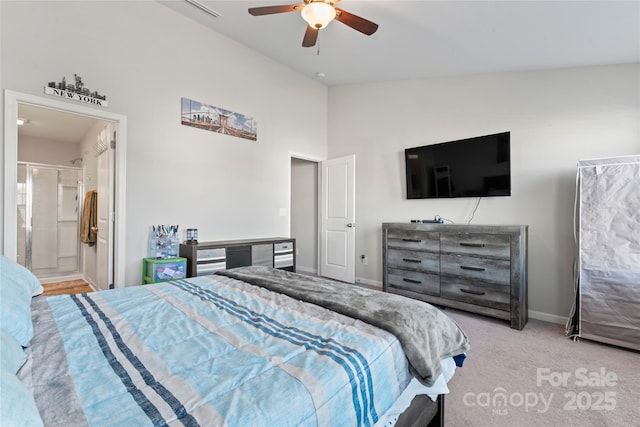 carpeted bedroom featuring ceiling fan, vaulted ceiling, and ensuite bath