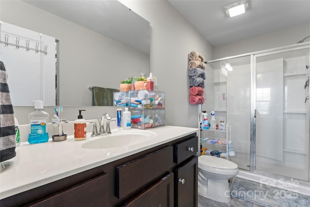 bathroom with vanity, toilet, and a shower with door