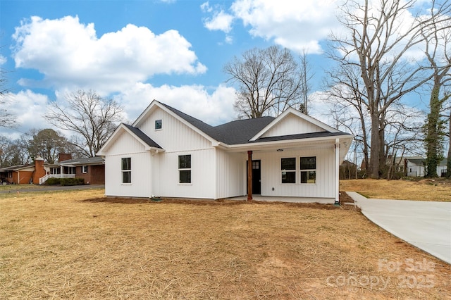 modern inspired farmhouse with a shingled roof and a front yard