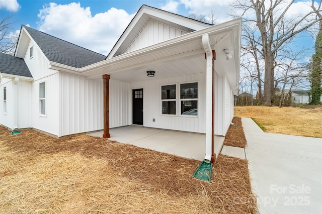 view of front of house with roof with shingles and board and batten siding