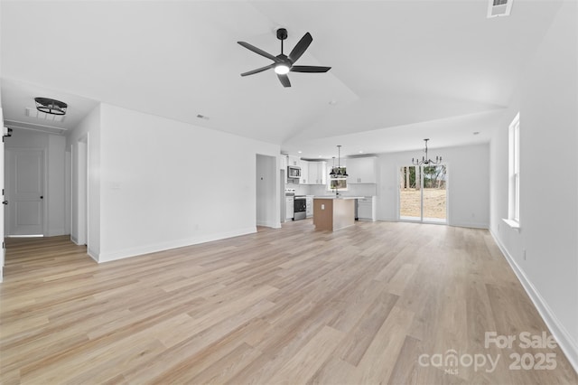 unfurnished living room with high vaulted ceiling, ceiling fan with notable chandelier, visible vents, baseboards, and light wood-type flooring