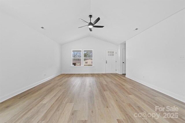 empty room with ceiling fan, lofted ceiling, light wood-style flooring, visible vents, and baseboards