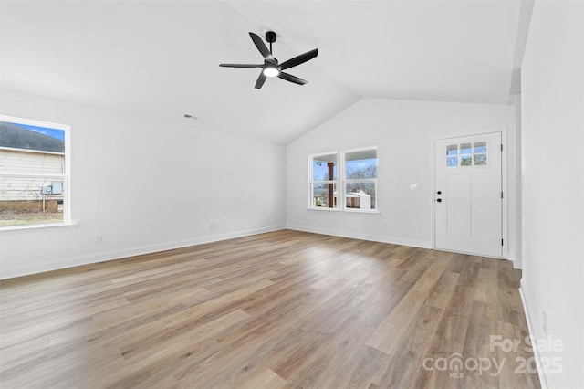 unfurnished living room featuring vaulted ceiling, light wood-type flooring, visible vents, and a healthy amount of sunlight