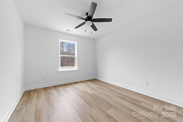 unfurnished room with light wood finished floors, a ceiling fan, visible vents, and baseboards