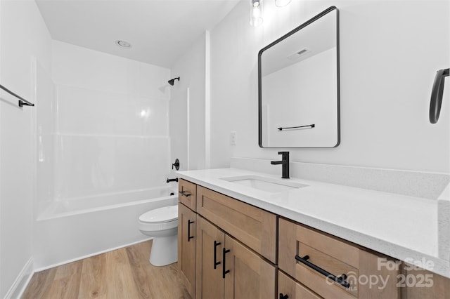 bathroom with shower / bathtub combination, visible vents, toilet, vanity, and wood finished floors