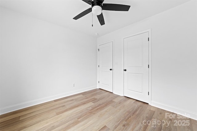 unfurnished bedroom with light wood-type flooring, ceiling fan, and baseboards