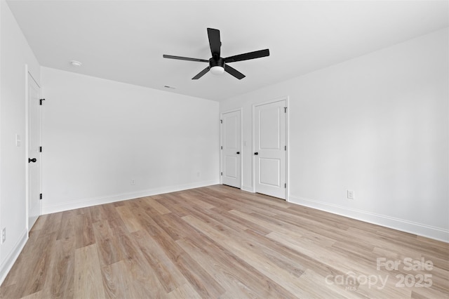 unfurnished room featuring a ceiling fan, light wood-type flooring, and baseboards