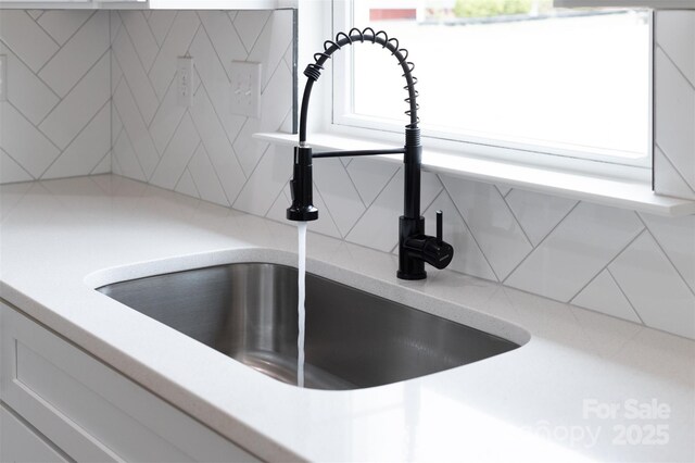 details featuring decorative backsplash, a sink, and light countertops