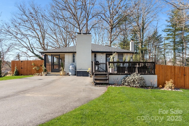 rear view of property with a wooden deck and a yard