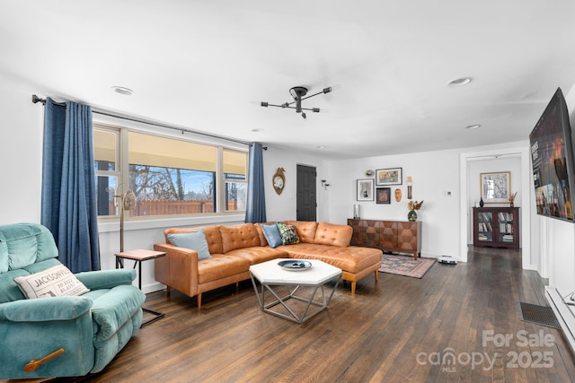 living room featuring a notable chandelier and dark wood-type flooring