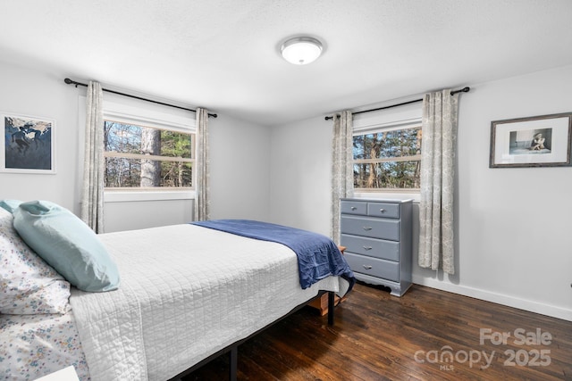 bedroom with dark wood-type flooring and multiple windows