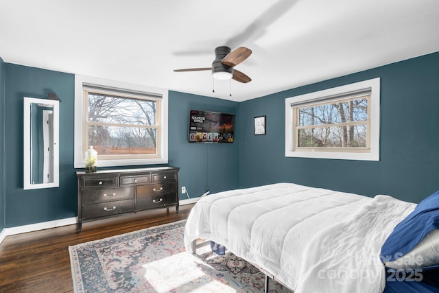 bedroom with dark hardwood / wood-style flooring and ceiling fan