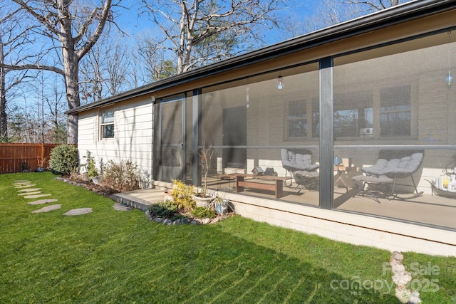 back of property featuring a lawn and a sunroom