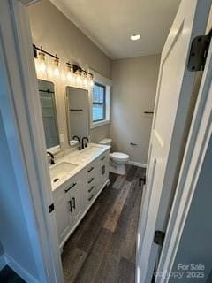 bathroom with hardwood / wood-style floors, vanity, and toilet