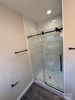 bathroom with wood-type flooring and an enclosed shower