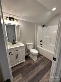 full bathroom featuring wood-type flooring, lofted ceiling, toilet, vanity, and shower / bathtub combination