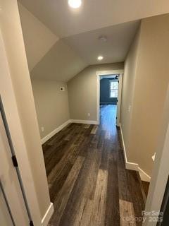 additional living space featuring dark wood-type flooring and lofted ceiling