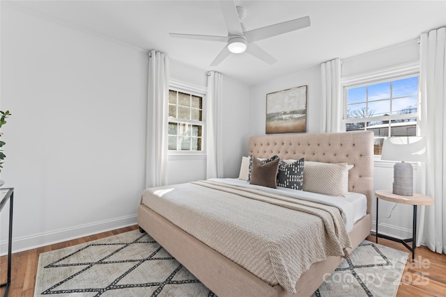 bedroom featuring ceiling fan, baseboards, and wood finished floors