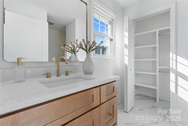 bathroom featuring marble finish floor and vanity