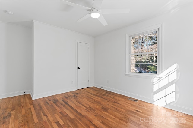 unfurnished room with baseboards, visible vents, and wood finished floors