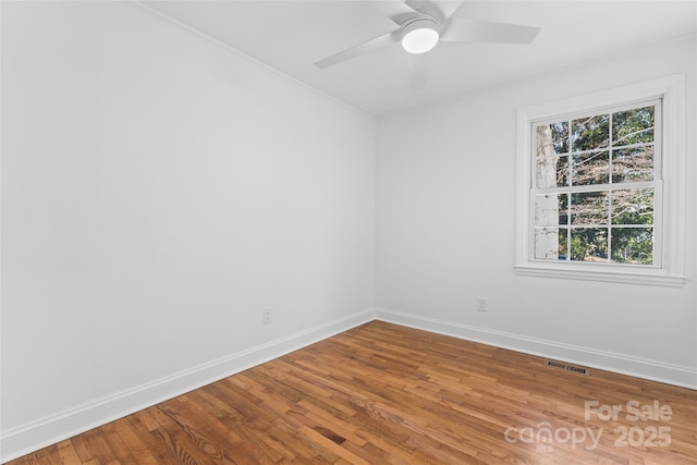 unfurnished room featuring visible vents, baseboards, ceiling fan, and wood finished floors