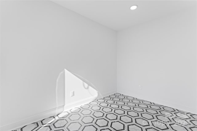 empty room featuring baseboards and recessed lighting