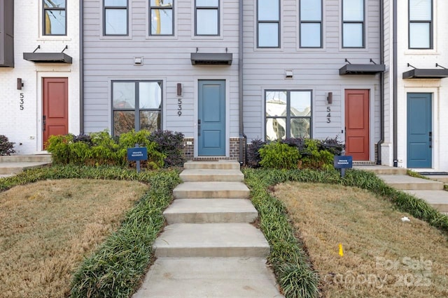 property entrance featuring a lawn