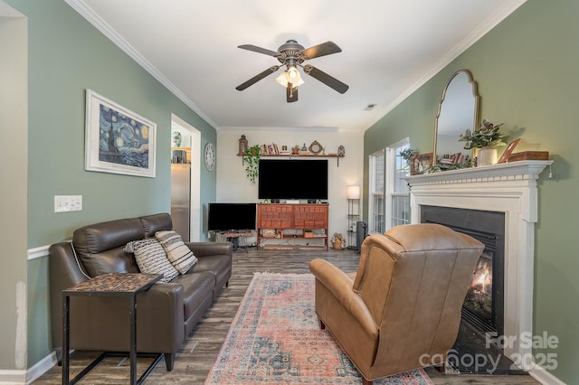 living room featuring hardwood / wood-style flooring, ceiling fan, and crown molding