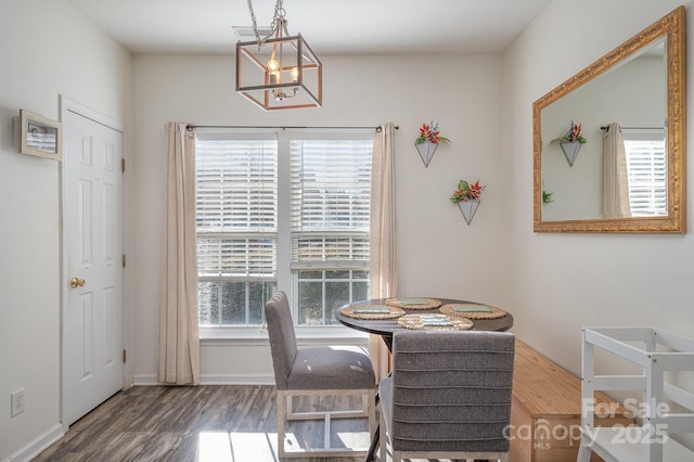 dining room with dark hardwood / wood-style floors, a healthy amount of sunlight, and a notable chandelier