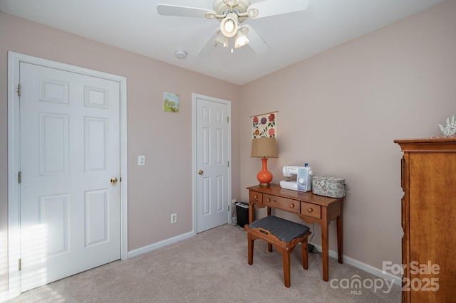 carpeted home office featuring ceiling fan