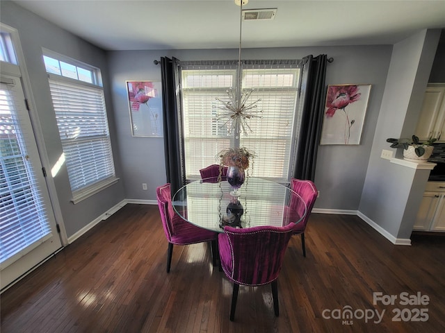 dining area featuring a notable chandelier and dark wood-type flooring