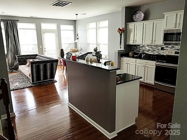 kitchen featuring white cabinetry, decorative backsplash, plenty of natural light, and appliances with stainless steel finishes