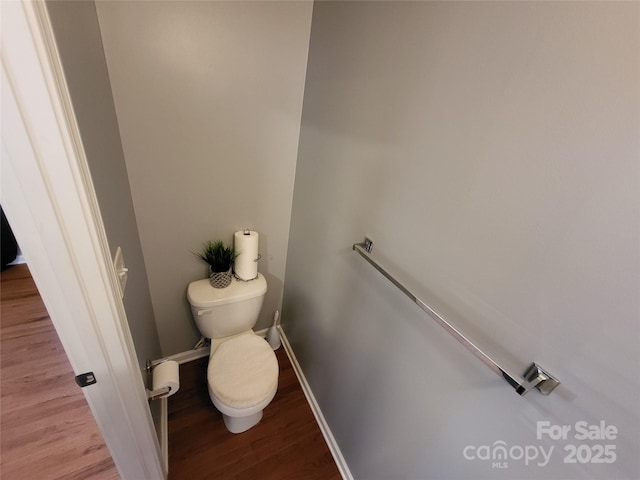 bathroom with hardwood / wood-style flooring and toilet