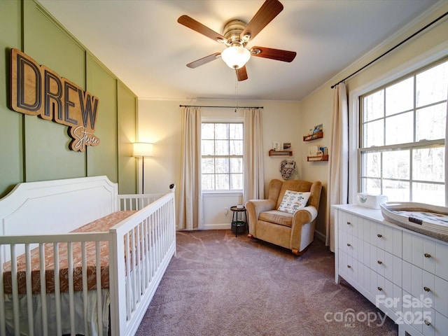 bedroom with a crib, carpet floors, and ceiling fan